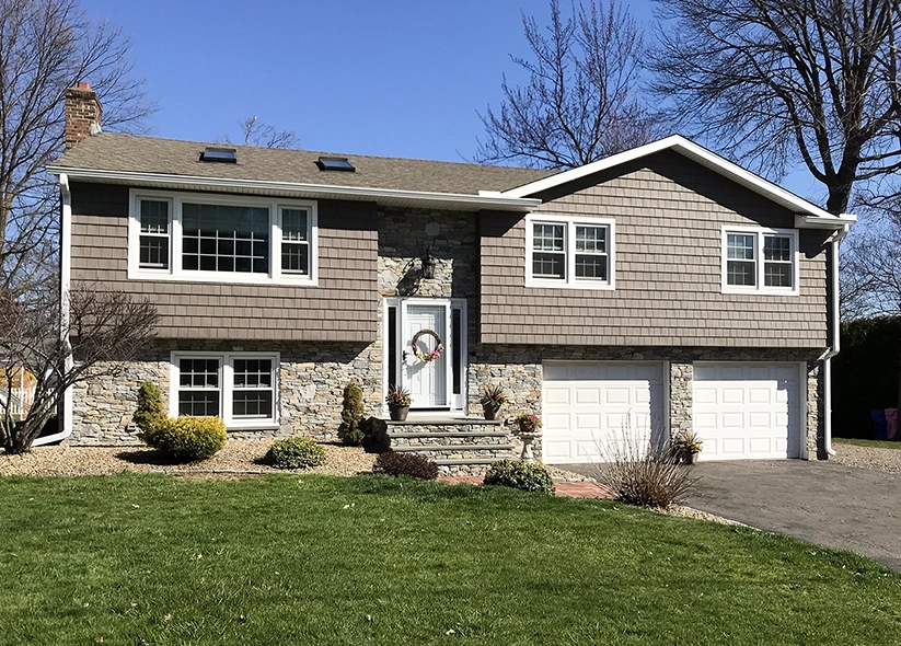 A house with a roof replacement, vinyl siding replacement and new garage doors